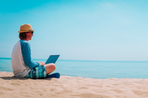 man working in laptop from the beach